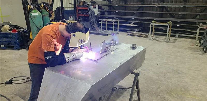 Worker assembling a metal unit